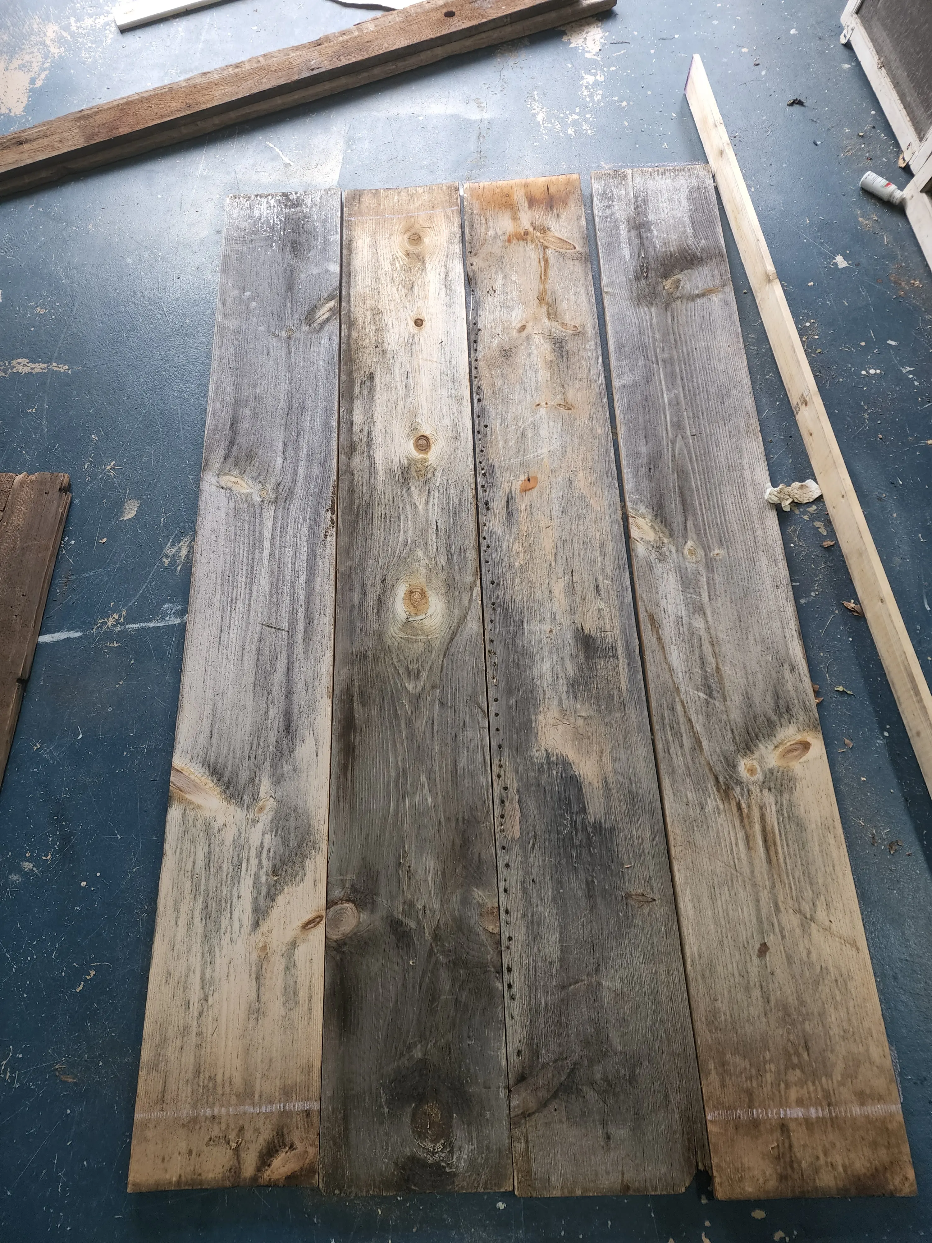weathered pine boards 1x8x8 naturally weathered laying on a garage floor